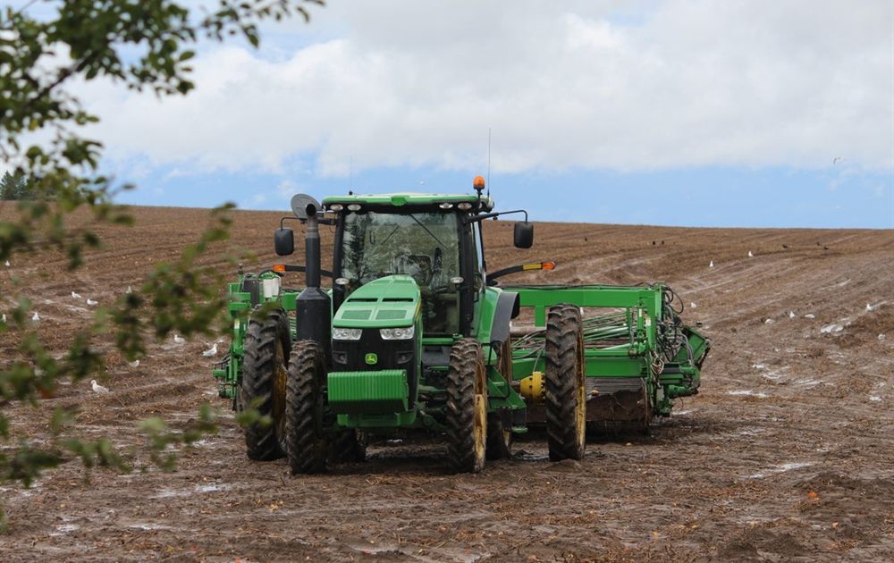 Tractor working a field with a mounted implement