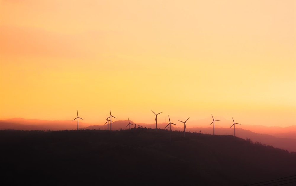 Wind turbines along a ridge line at sunset